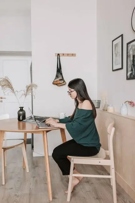 Home office design ideas - Woman working from laptop at kitchen table