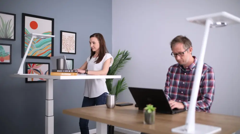 What Is An Active Workstation? - Woman at standing desk and man sitting at desk